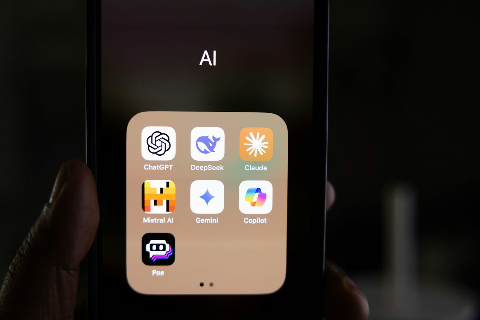 A phone showing an AI app folder — ChatGPT, DeepSeek, Claude, Gemini, Copilot.