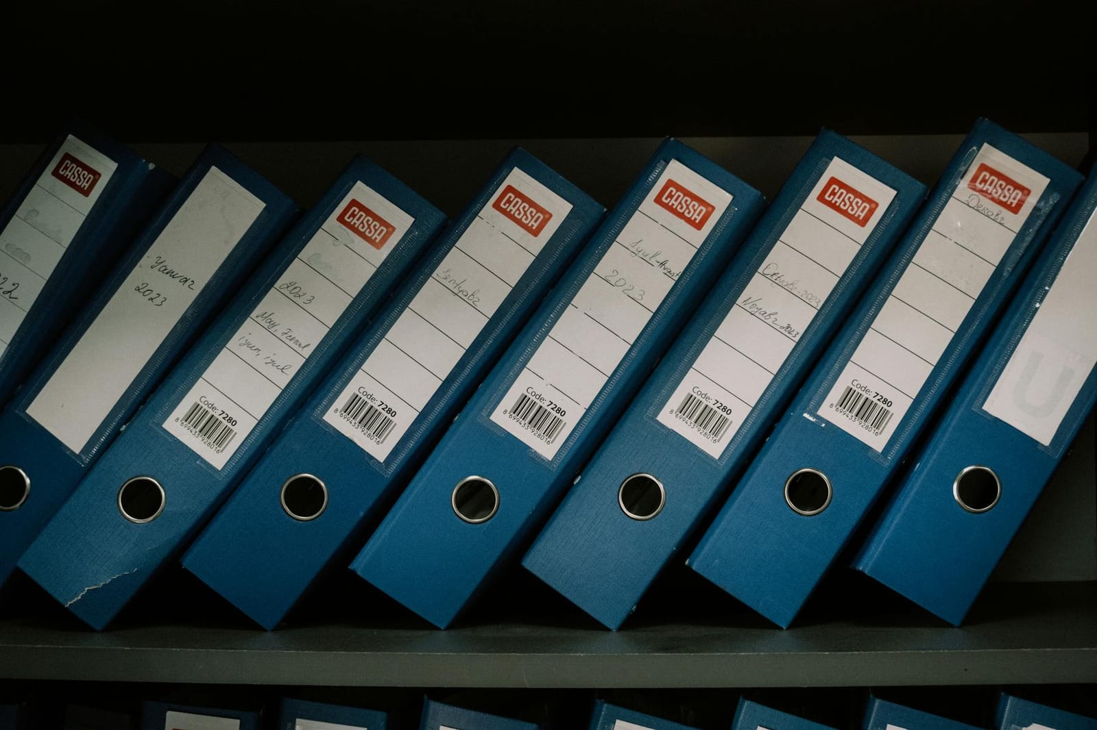 Labelled archive binders organised on a shelf.